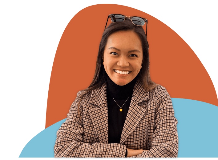 me smiling, wearing a blazer and turtleneck against two orange and blue freeform background blobs